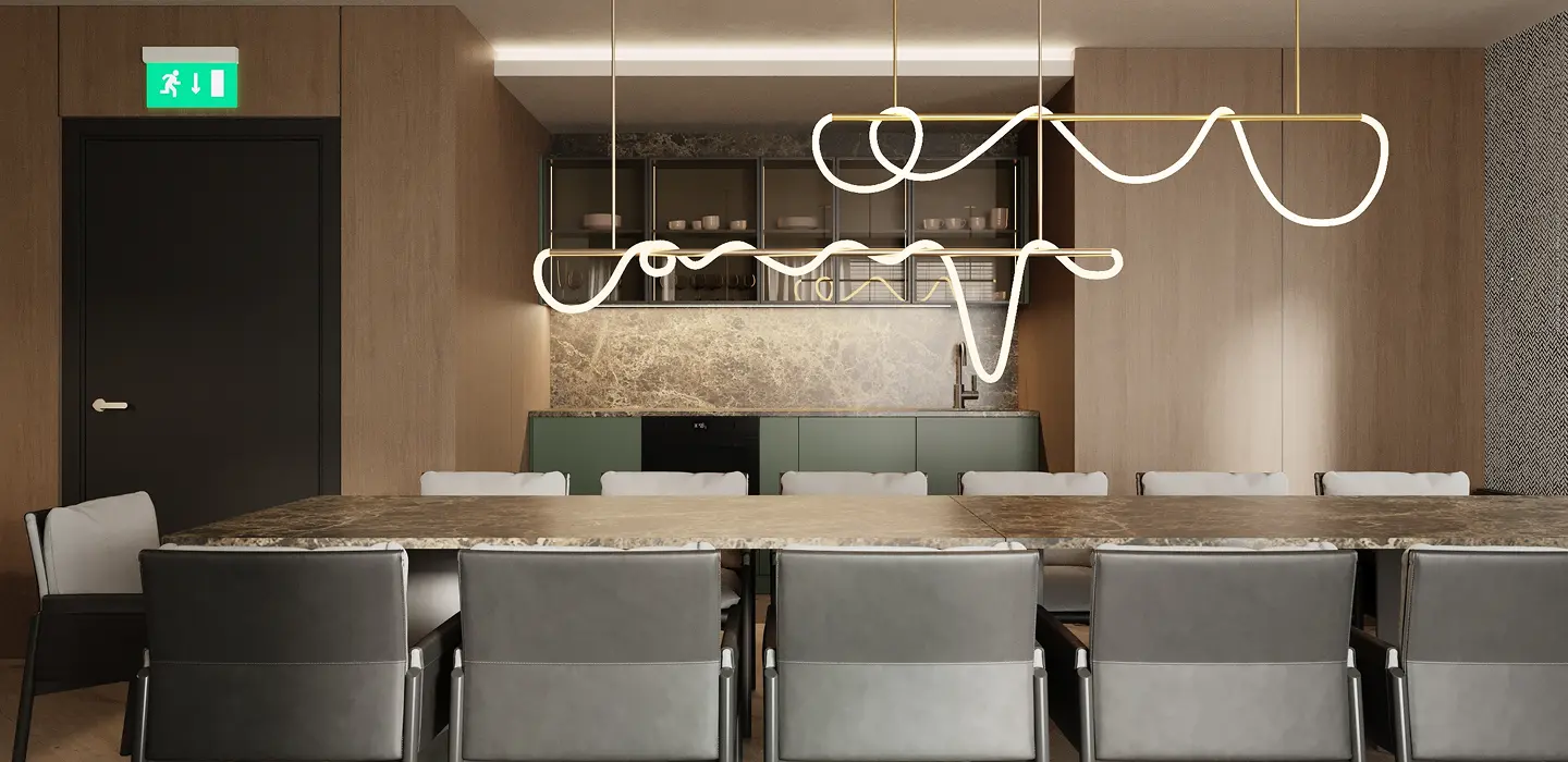 Gemeinschaftsküche mit langem Esstisch, grünen Samtstühlen und auffälligen, geschwungenen LED-Leuchtröhren.